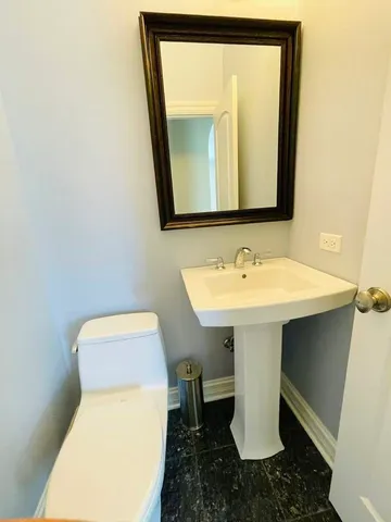 a bathroom with a toilet sink and mirror