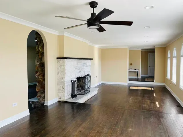 a view of empty room with fireplace and wooden floor