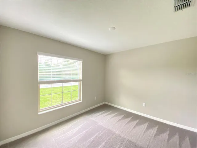 an empty room with a window and wooden floor