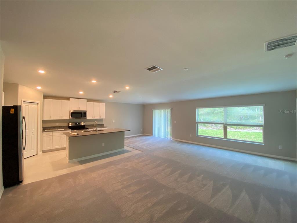 2530 Southwest 167th Loop Ocala, FL 34473 - Photo 3 of 31 a kitchen with stainless steel appliances kitchen island granite countertop a stove top oven a sink and a refrigerator