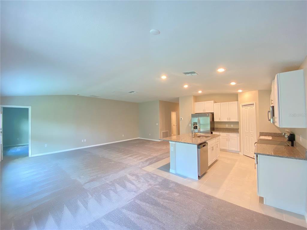 2530 Southwest 167th Loop Ocala, FL 34473 - Photo 5 of 31 a view of a kitchen with kitchen island a sink wooden floor and a view of living room