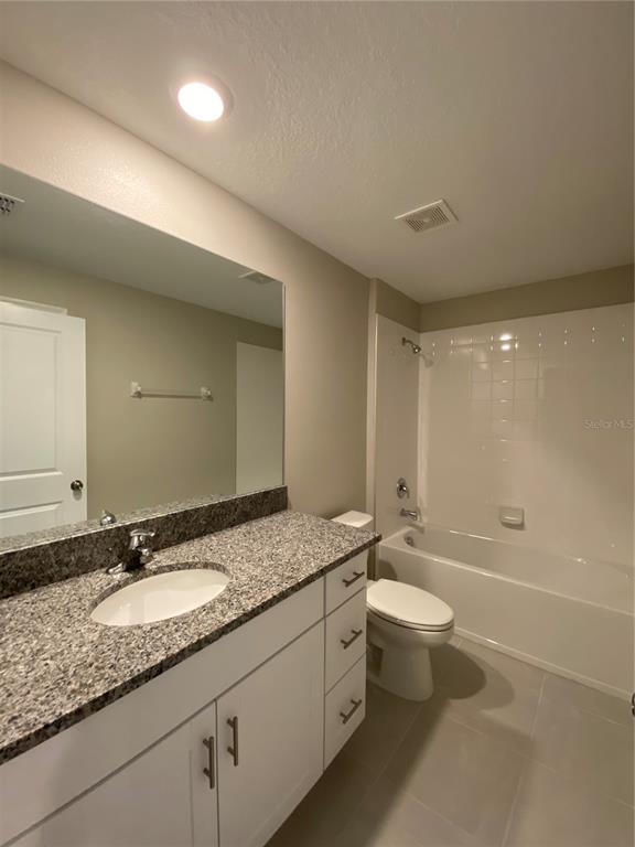2530 Southwest 167th Loop Ocala, FL 34473 - Photo 9 of 31 a bathroom with a granite countertop sink a toilet and bathtub