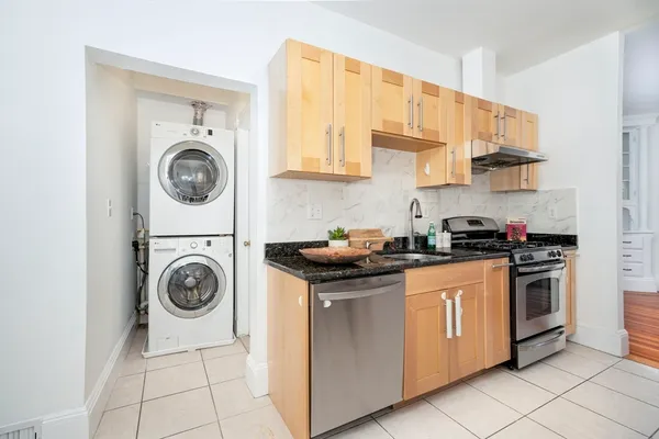 a kitchen with granite countertop a stove top oven sink and cabinets