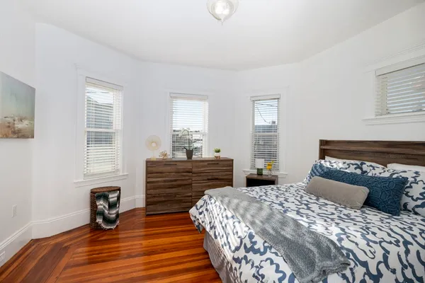 a bedroom with a bed and wooden floor
