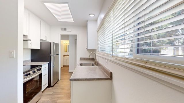 a kitchen with granite countertop a sink and a window