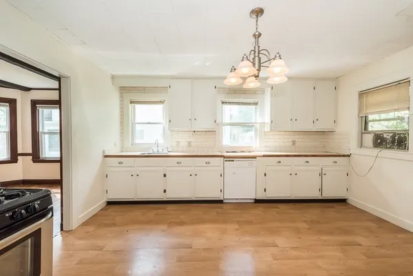 a kitchen with granite countertop white cabinets white stainless steel appliances with a sink and dishwasher