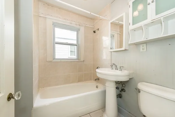 a bath room with a toilet sink and a bath tub
