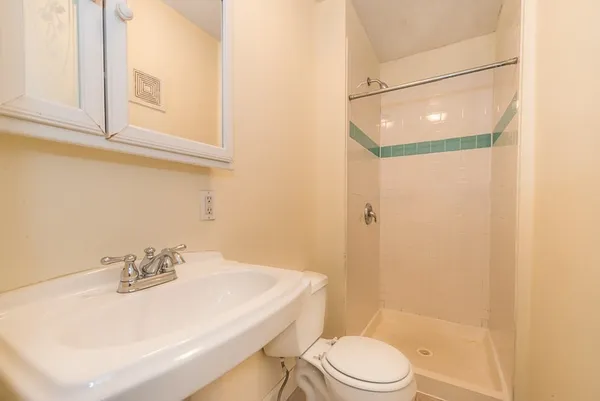 a bathroom with a sink a toilet and shower