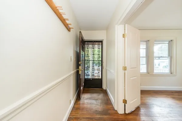 a view of a hallway with wooden floor and stairs