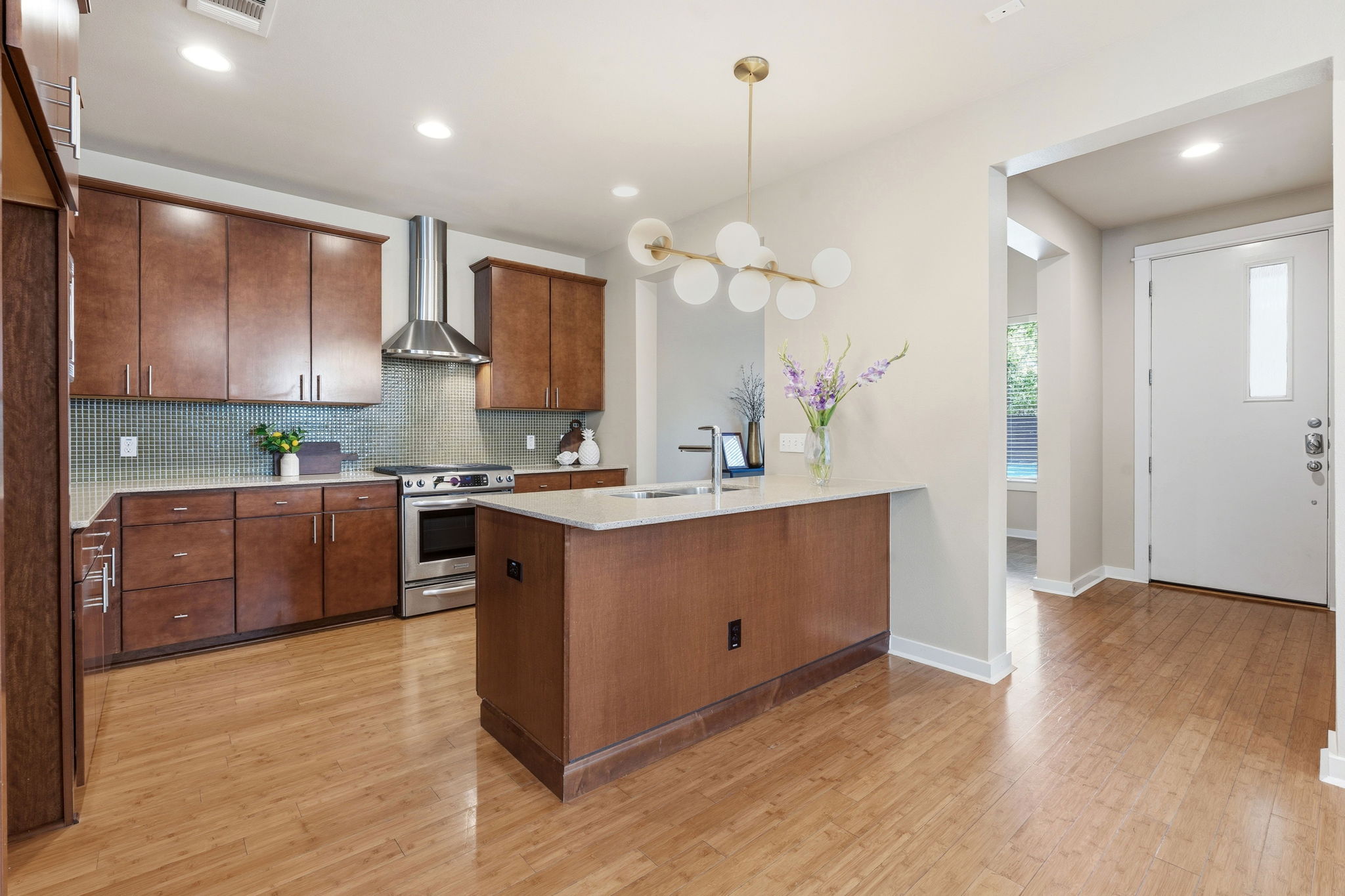 2911 Corbin Lane Austin, TX 78704 - Photo 3 of 37 a kitchen with kitchen island granite countertop a sink cabinets and wooden floor
