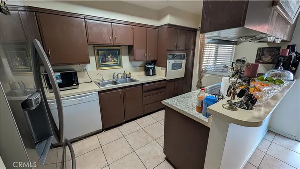 a kitchen with stainless steel appliances a sink a stove a refrigerator and cabinets