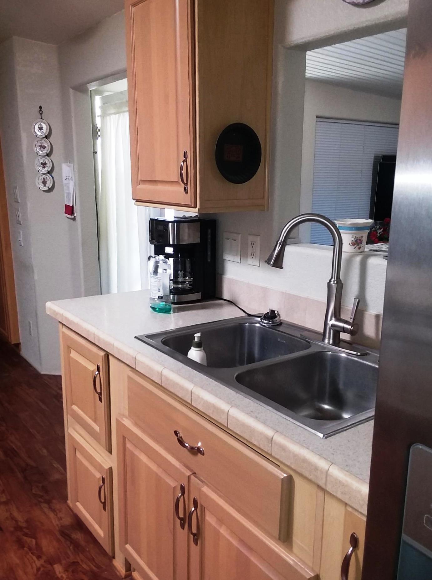 84136 Ave 44, Unit 593 Indio, CA 92203 - Photo 13 of 31 a kitchen with a sink and a stove with wooden floor