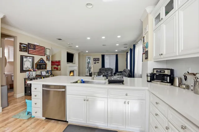 a kitchen with white cabinets and sink