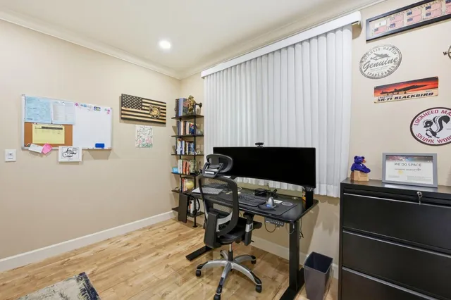 a view of a workspace with furniture and a window
