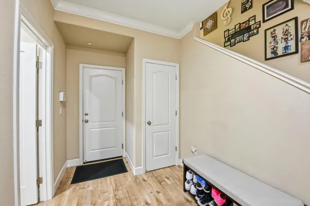 a view of a hallway to a bedroom with wooden floor and closet