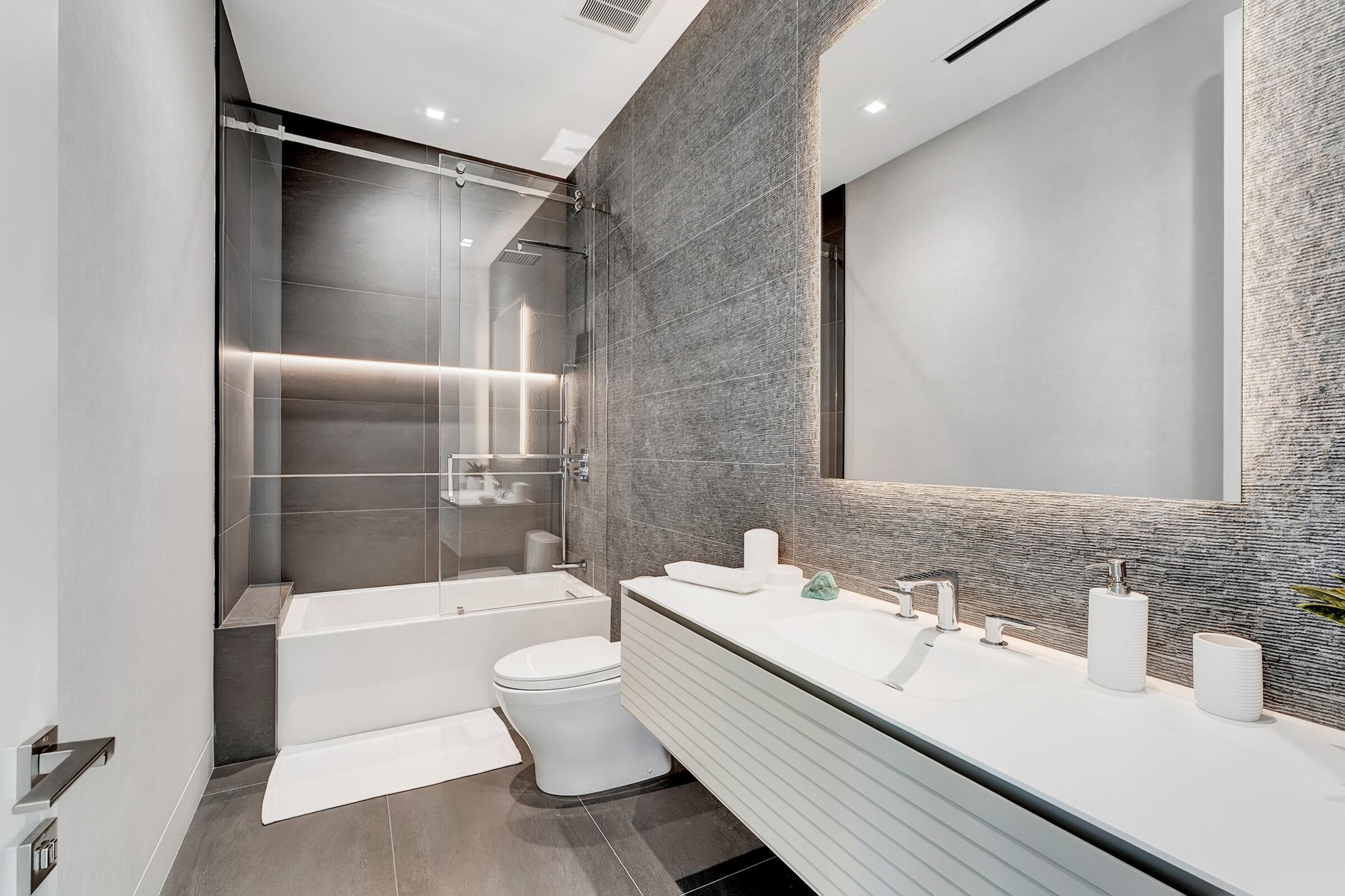 829 Orchid Drive Boca Raton, FL 33432 - Photo 74 of 102 a bathroom with a bathtub shower sink vanity and toilet