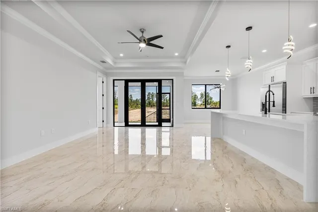 a large white kitchen with cabinets a sink and stainless steel appliances