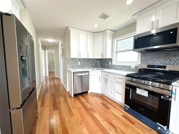 a kitchen with stainless steel appliances a white stove top oven and a refrigerator