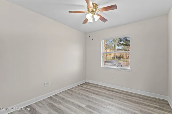 an empty room with a window and a fan