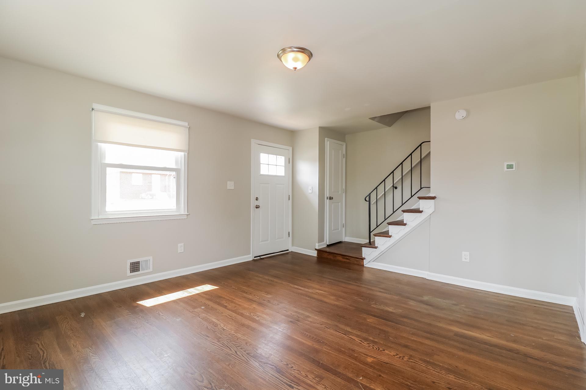 5674 Leiden Road Baltimore, MD 21206 - Photo 3 of 14 a view of an empty room with wooden floor and a window