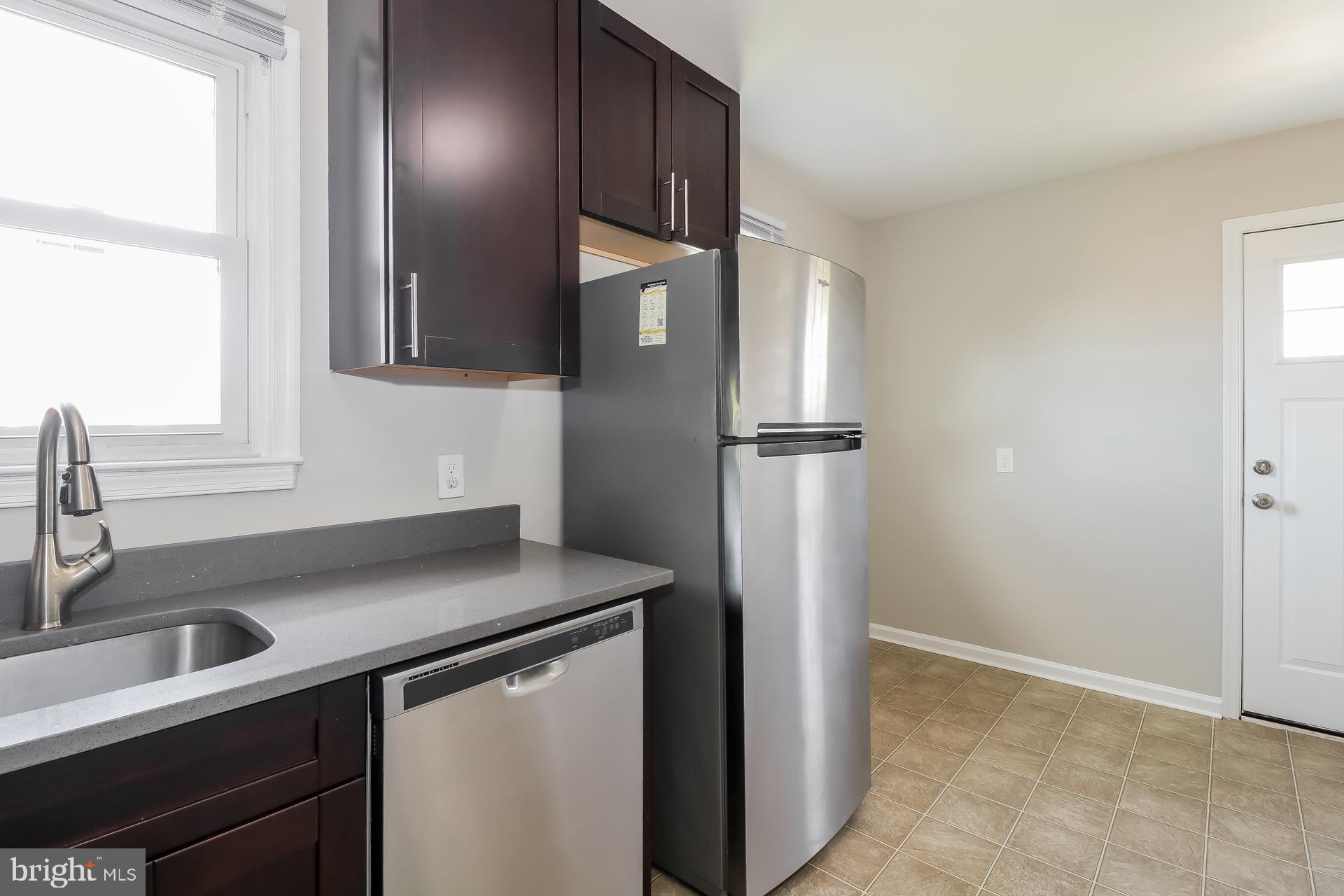 5674 Leiden Road Baltimore, MD 21206 - Photo 5 of 14 a kitchen with stainless steel appliances granite countertop a sink stove and refrigerator