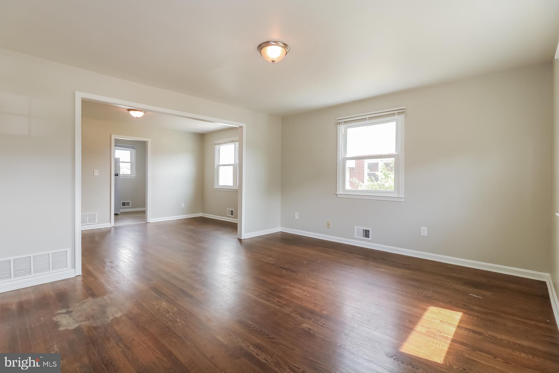 5674 Leiden Road Baltimore, MD 21206 - Photo 8 of 14 an empty room with wooden floor and windows