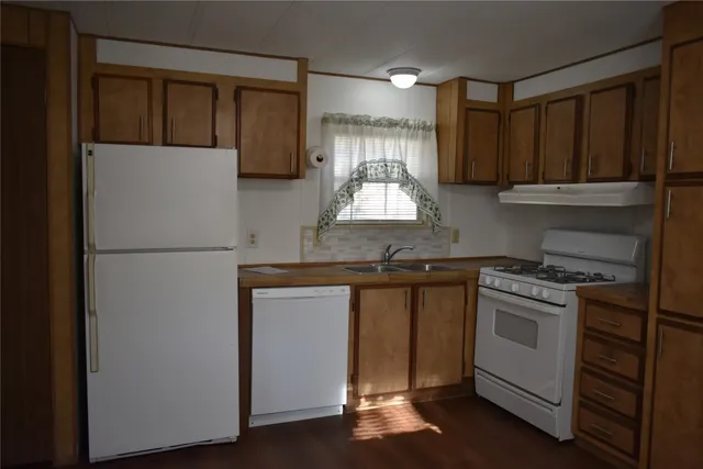 a kitchen with granite countertop a refrigerator stove and sink