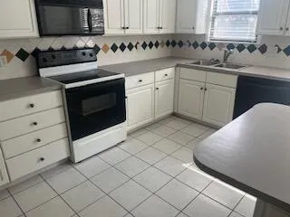 a kitchen with a sink stove and cabinets