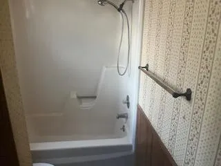 a front view of a house with garden and a tree