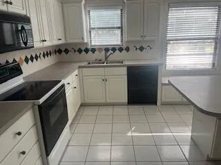 a kitchen with a sink a stove and cabinets