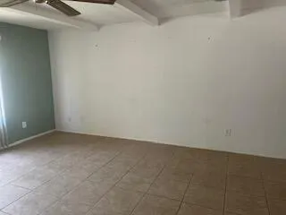 a view of a livingroom with an empty space and a window
