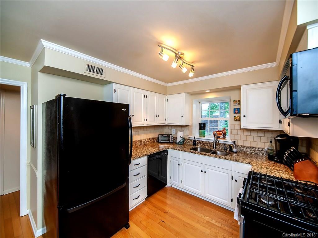 1712 Roxborough Road, Unit E Charlotte, NC 28211 - Photo 8 of 23 a kitchen with stainless steel appliances a stove refrigerator sink and cabinets