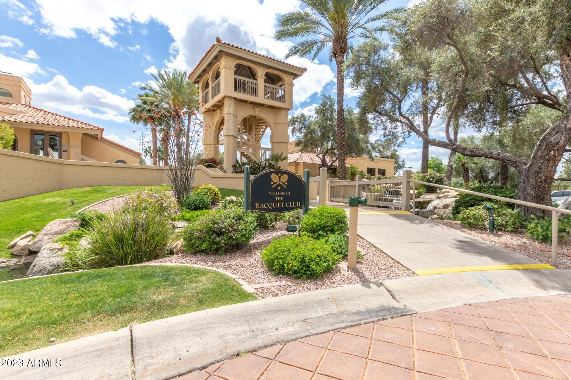 9711 East Mountain View Road, Unit 1502 Scottsdale, AZ 85258 - Photo 40 of 43 a front view of a house with a yard and potted plants
