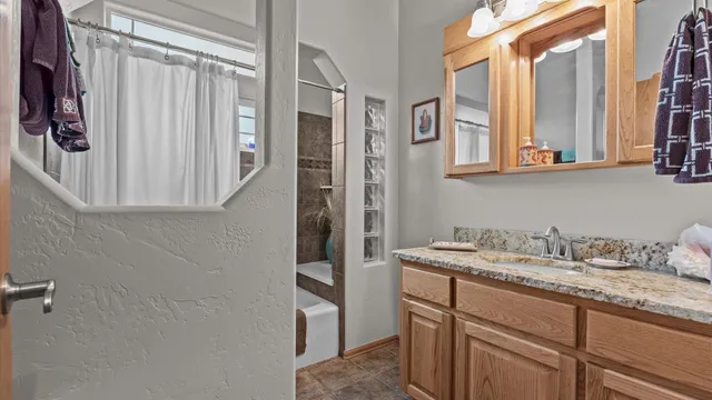 a bathroom with a granite countertop sink a toilet and mirror