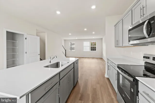 a kitchen with stainless steel appliances granite countertop a sink stove and cabinets