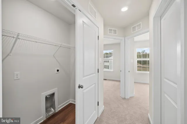 a view of a hallway with wooden floor and closet
