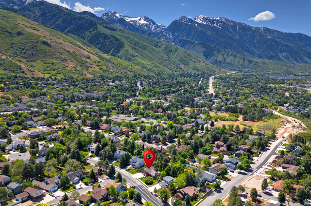 3310 Creek Road Salt Lake City, UT 84121 - Photo 45 of 49 Aerial perspective showcasing a residential neighborhood with tree-lined streets, against a backdrop of green hills and snow-capped mountains