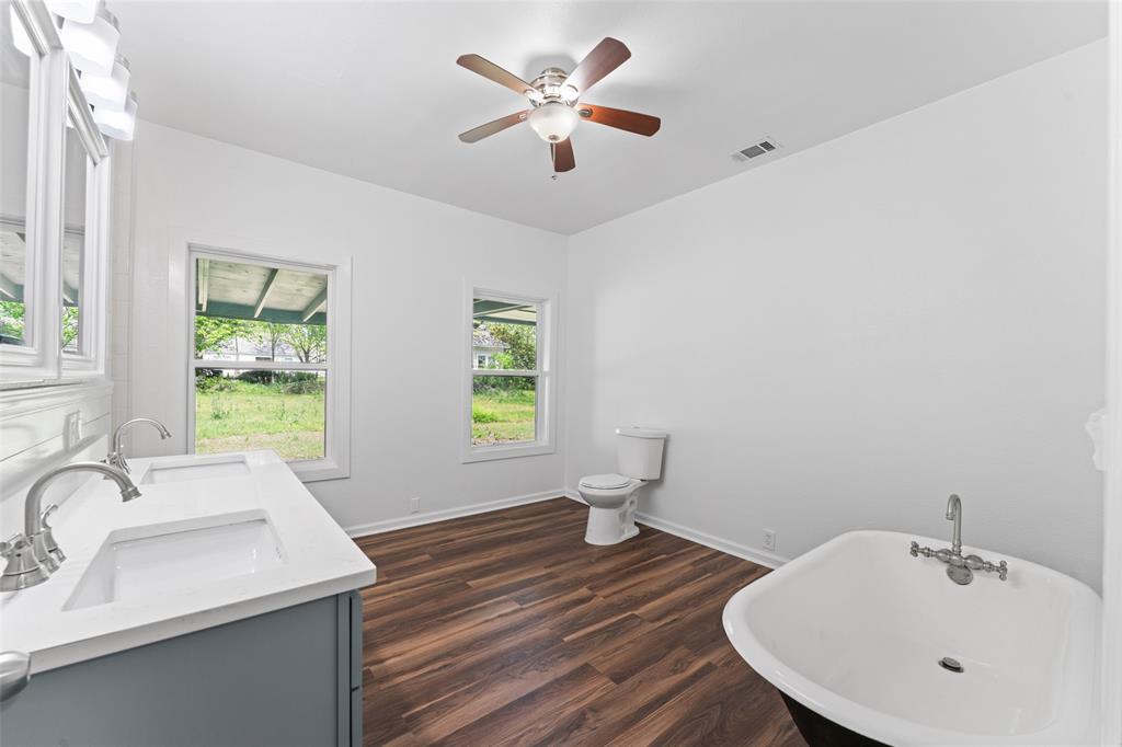 2405 Monroe Street Commerce, TX 75428 - Photo 17 of 31 a bathroom with a sink and a large mirror