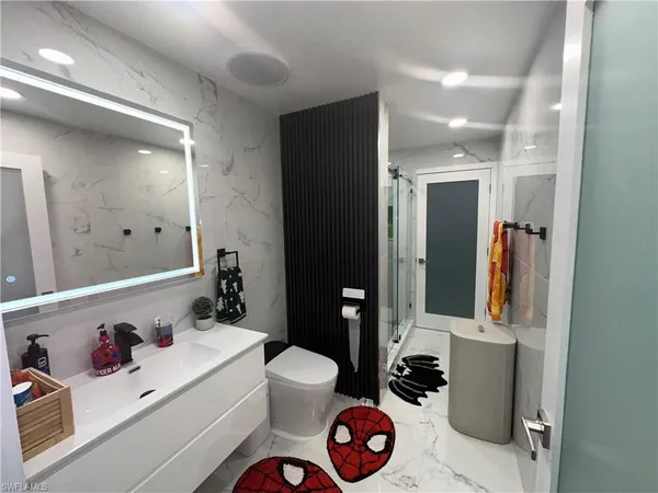 a bathroom with a sink a toilet and shower