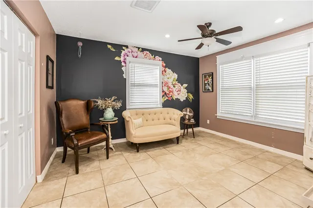 a living room with furniture a flat screen tv and a large window