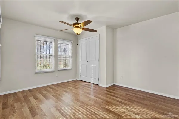 a view of an empty room with window and wooden floor