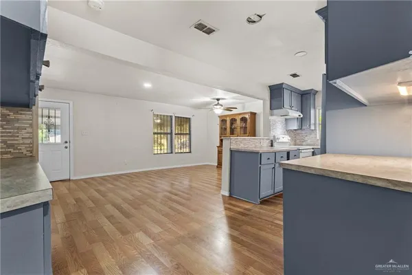 a kitchen with granite countertop a sink cabinets and wooden floor