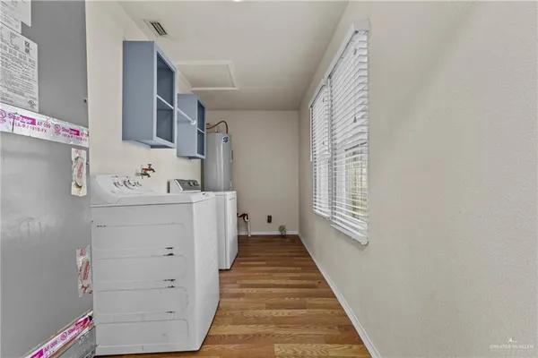 a hallway with cabinets washer and dryer