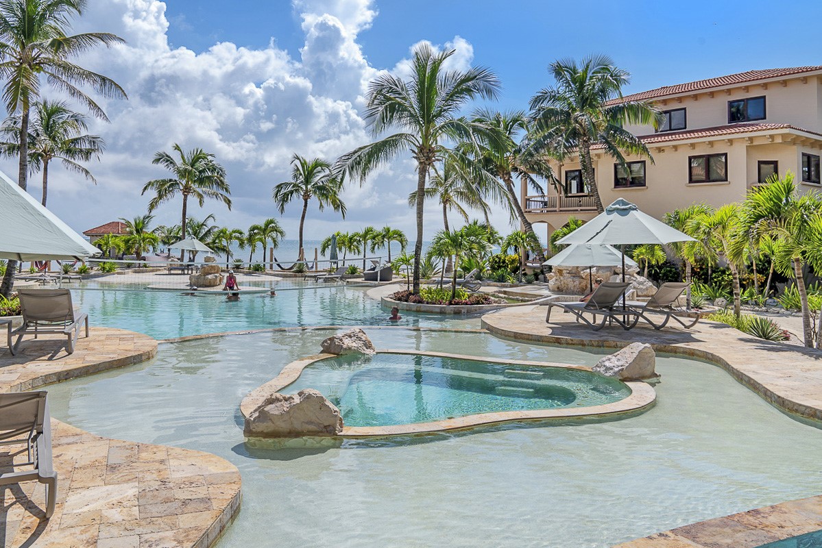 1.3 Miles North San Pedro, Unit CASITA1 Robstown, TX 78380 - Photo 37 of 37 a view of a swimming pool with a lawn chairs and palm tree