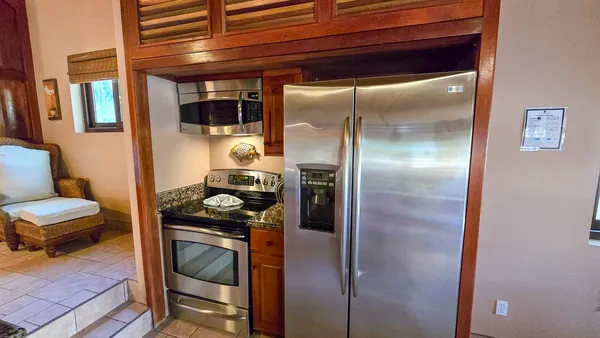 a kitchen with a refrigerator and a stove top oven