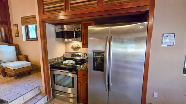 a kitchen with a refrigerator and a stove top oven