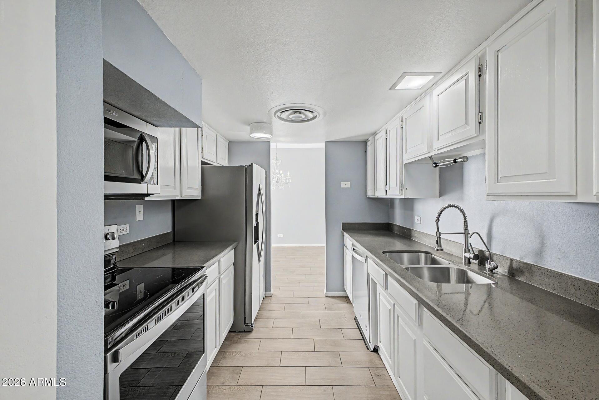 207 West Clarendon Avenue, Unit B2 Phoenix, AZ 85013 - Photo 7 of 30 a kitchen with stainless steel appliances granite countertop a sink stove and refrigerator