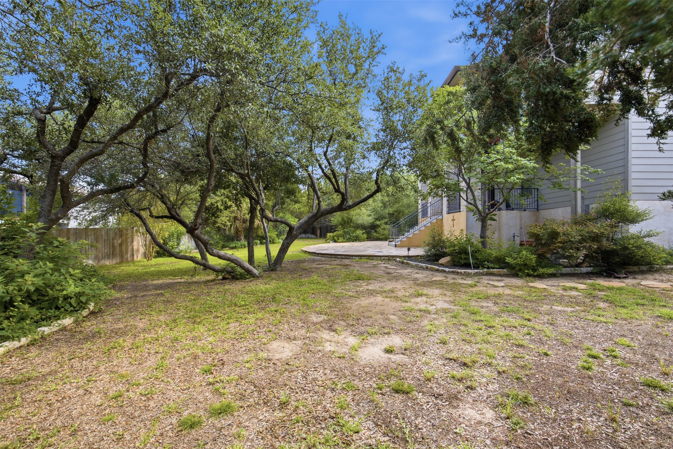 700 Augusta Circle Point Venture, TX 78645 - Photo 25 of 35 Mature trees frame a peaceful yard leading to a private patio, perfect for outdoor enjoyment.