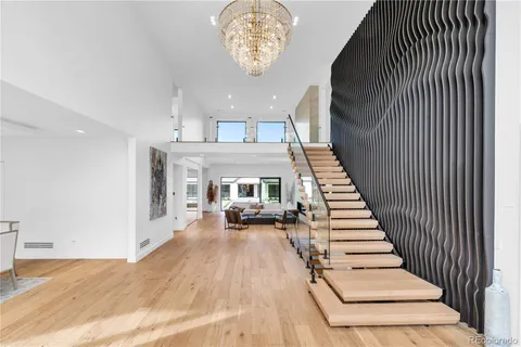 a view of a dining room with furniture a livingroom and chandelier