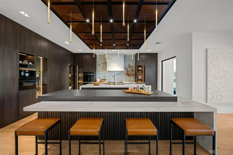 a kitchen with stainless steel appliances granite countertop a table chairs sink and cabinets